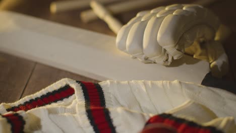 cricket still life with close up of bat ball gloves stumps jumper and bails lying on wooden surface in locker room 3