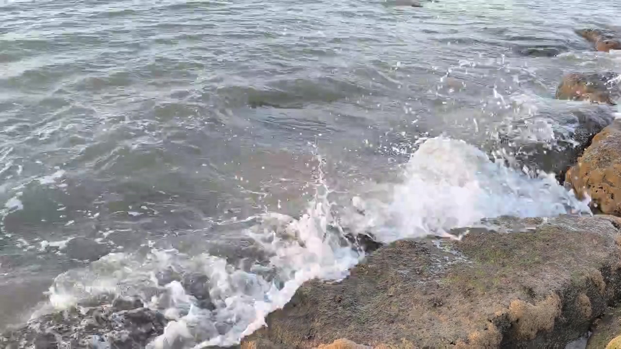 Le onde dell'oceano si schiantano contro la costa rocciosa
