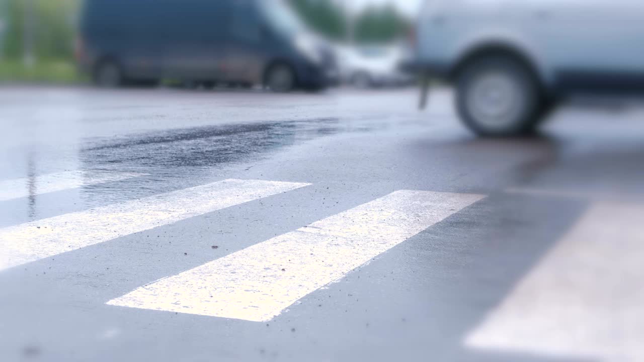 소년은 비가 내리는 보행자 교차로에서 길을 건너고 다리를 가까이 습니다.