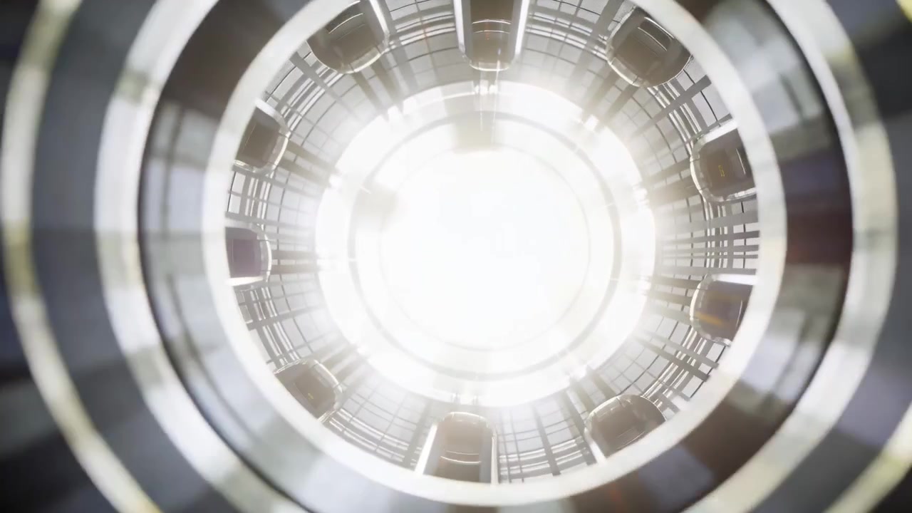 Telecamera che sale attraverso un pozzo metallico verso una luce brillante, mostrando anelli concentrici e capsule.