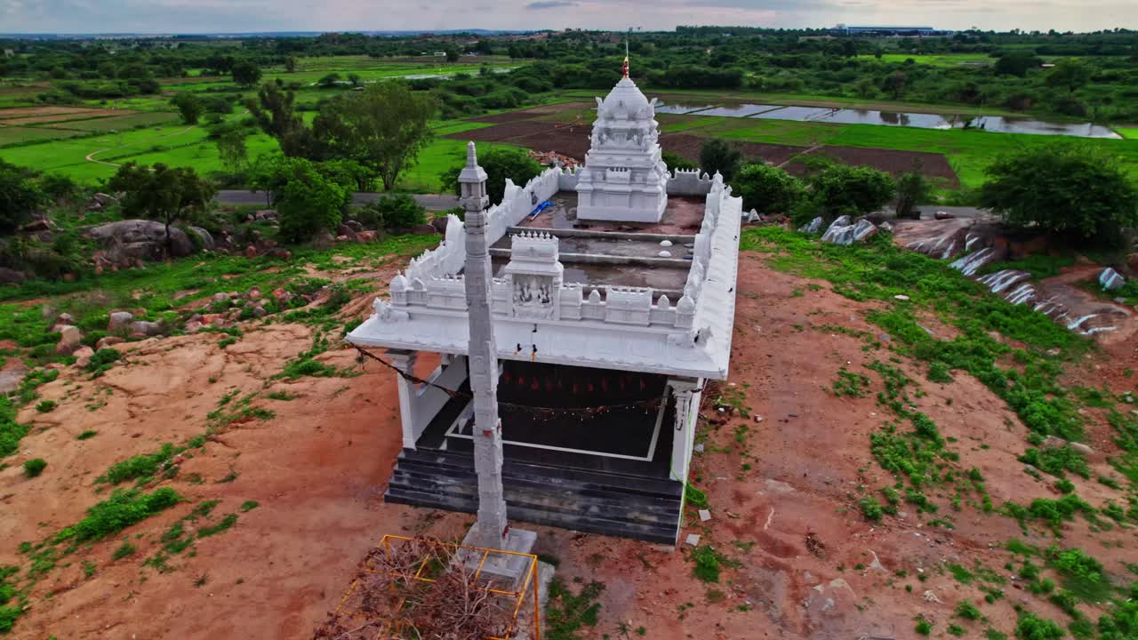 Temple with gopuram in the background farming land and trees at day time, semi circle, drone shot, 4k.