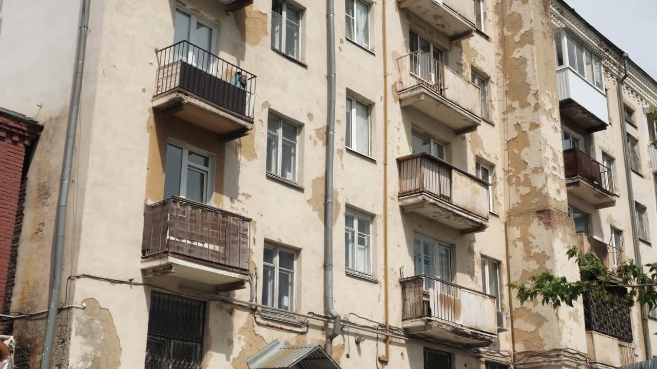 viejo edificio de apartamentos de varios pisos con pintura descascarada