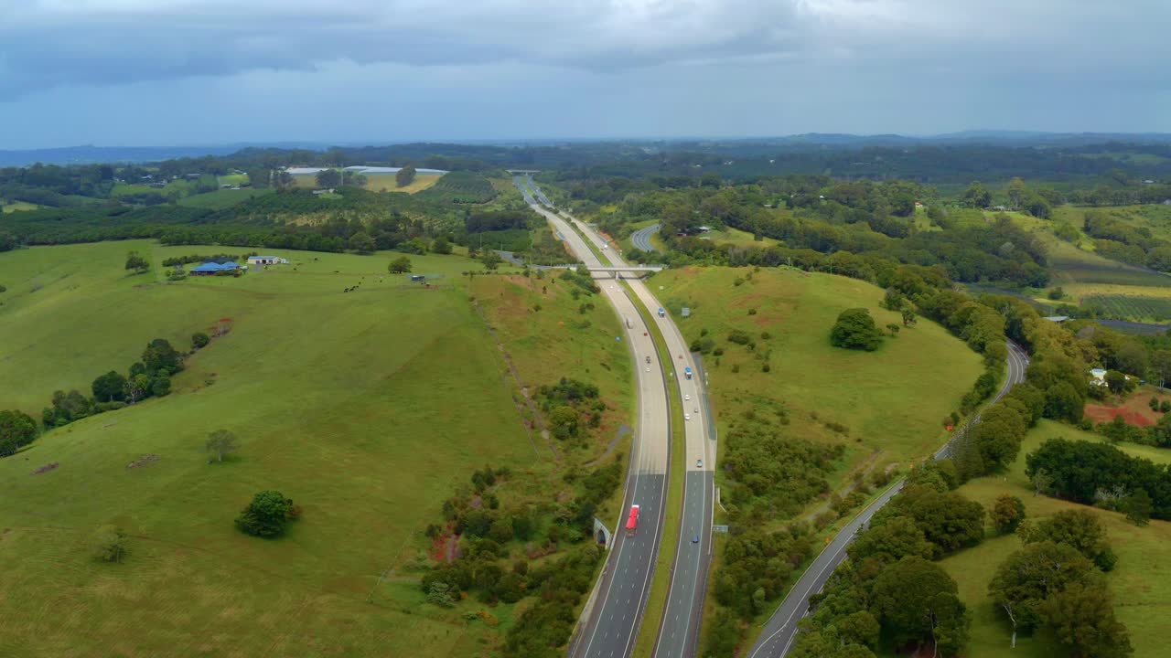 바이런 베이, 뉴 사우스 웨일즈, 호주에서 여름에 푸른 언덕과 들판을 따라 이중 차도에서 교통