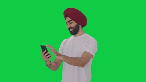 Feliz-Hombre-Indio-Sikh-Desplazándose-Por-La-Pantalla-Verde-Del-Teléfono