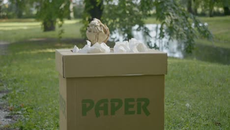 person throwing paper in paper garbage bin segregation for recycling purpose