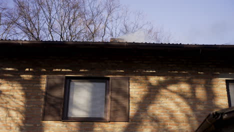 brick country house with chimney expelling smoke