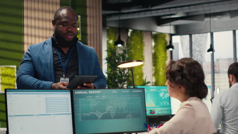diverse man and woman saluting each other with fist bump in the business space