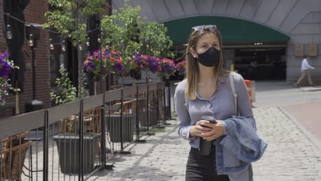 Young-woman-gets-fresh-air-after-corona-lockdown-wears-mandatory-black-face-mask