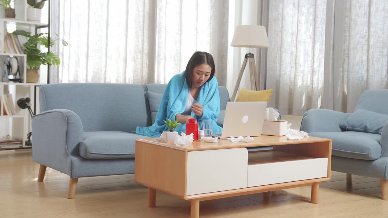 아픈 여자가 약을 먹고 집에서 휴식을 취하고 있습니다.