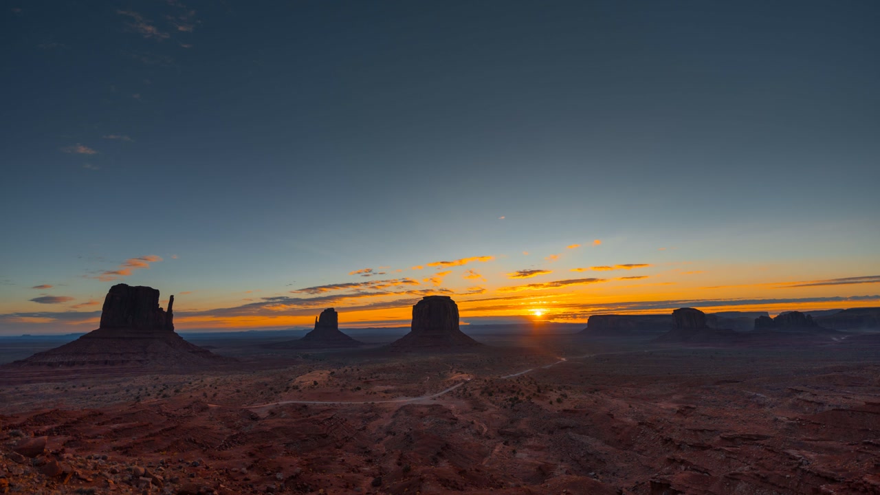 Starry night to sunrise transition over Monument Valley sandstone buttes, Arizona, scenic time lapse