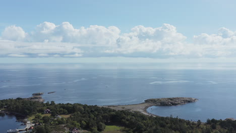 fliegen in richtung der küste einer bewaldeten insel, hinaus in richtung des ruhigen, endlosen meeres