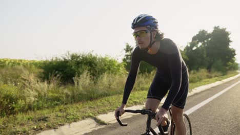 professional cycling athlete riding racing bicycle training for competition race on open road