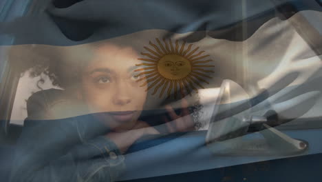 Animación-De-La-Bandera-Argentina-Sobre-Una-Mujer-Pensativa-Mirando-Por-La-Ventanilla-Del-Coche