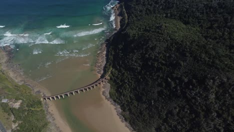 Tiro-De-Ojo-De-Pájaro-Con-Drones-De-Una-Playa-Salvaje-En-Sudáfrica---Un-Dron-Está-Dando-Vueltas-Alrededor-Del-Viejo-Puente-Ferroviario