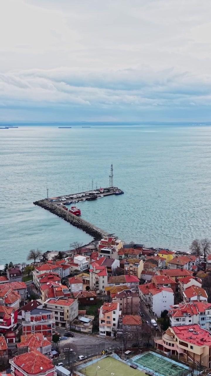 Vista di acqua calma e barche in lontananza da un punto elevato vicino alla costa