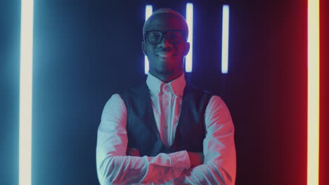 smiling man in formal attire with neon lighting