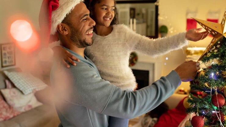 Animation of african american father and daughter decorating christmas tree
