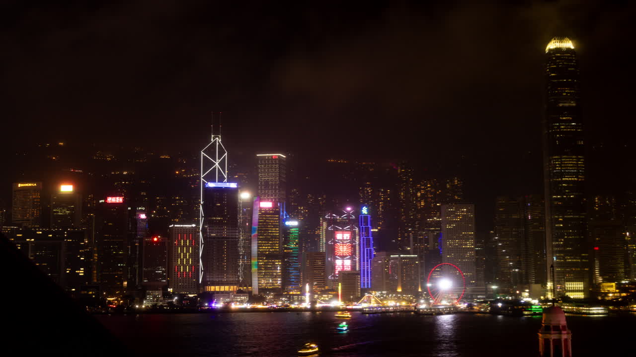 HONG KONG - 19 MARCH 2025 : Hong Kong Central city skyline filmed from across the harbour in kowloon with all the skyscrapers lit up at night advertisements