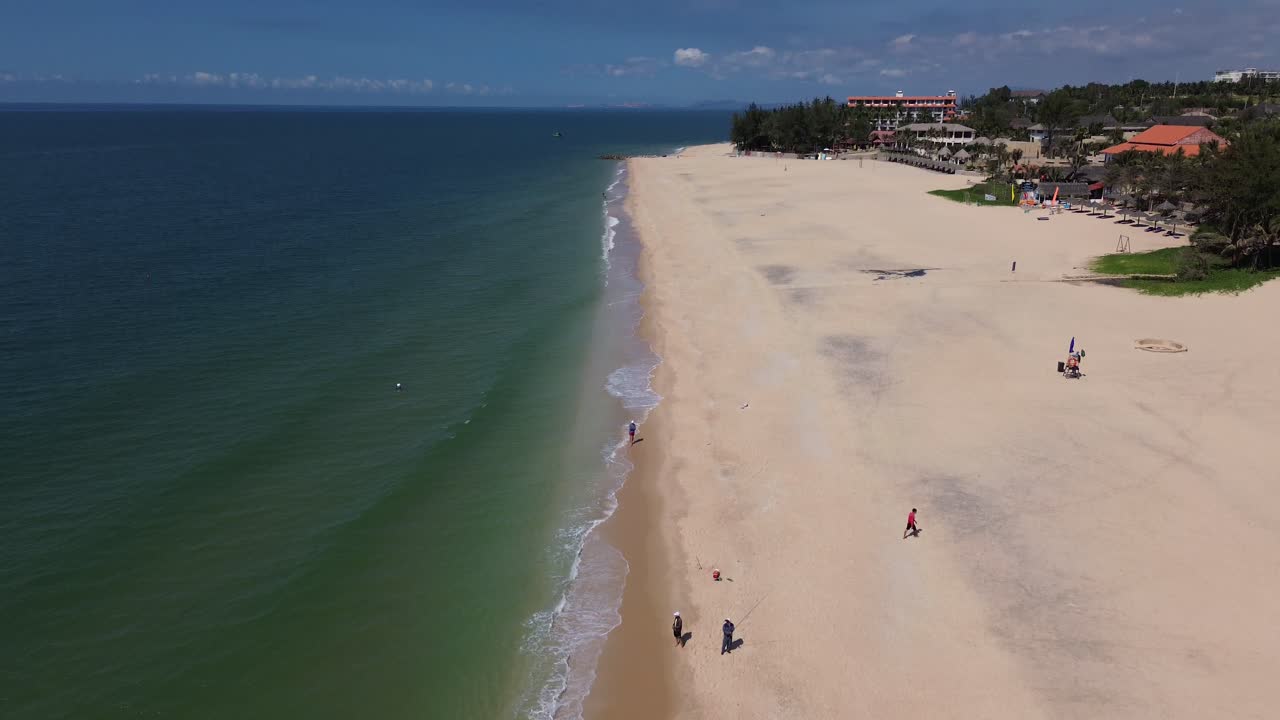 Drone shot from top-down to horizon revealing beach, boats, ocean, and tropical landscape at Mui Ne.