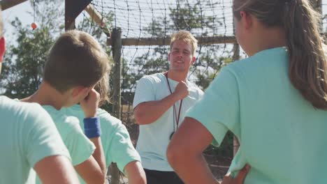 caucasian coach instructing kids at boot camp