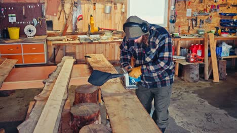 a person is planing a wooden board in a workshop as part of building a custom bench - close up