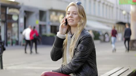 woman on bench and speaking on phone