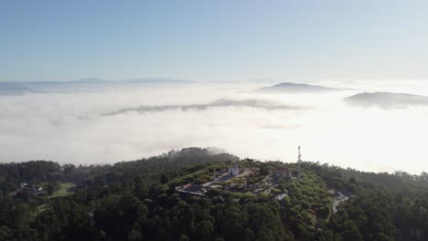 aerial view of a mountaintop church with fog below
