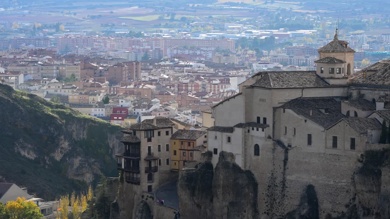 A detailed shot of the Hanging Houses (Casas Colgadas) in Cuenca, Spain, highlighting the historic wooden balconies and the way the stone walls merge with the cliff.