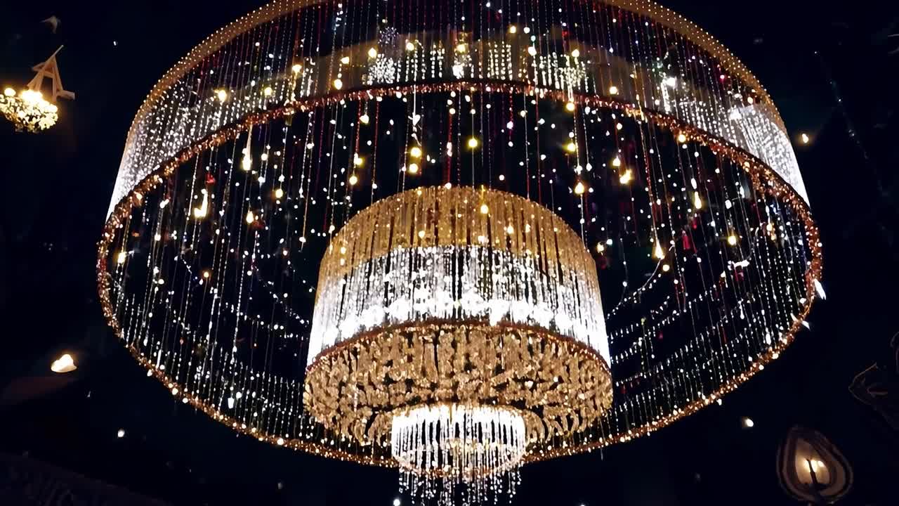 결혼식 장소 의 천장 에서 매달려 있는 큰 장식 된 들리어 는 아래 의 방 에 따뜻 한 빛 을 비추고 있다