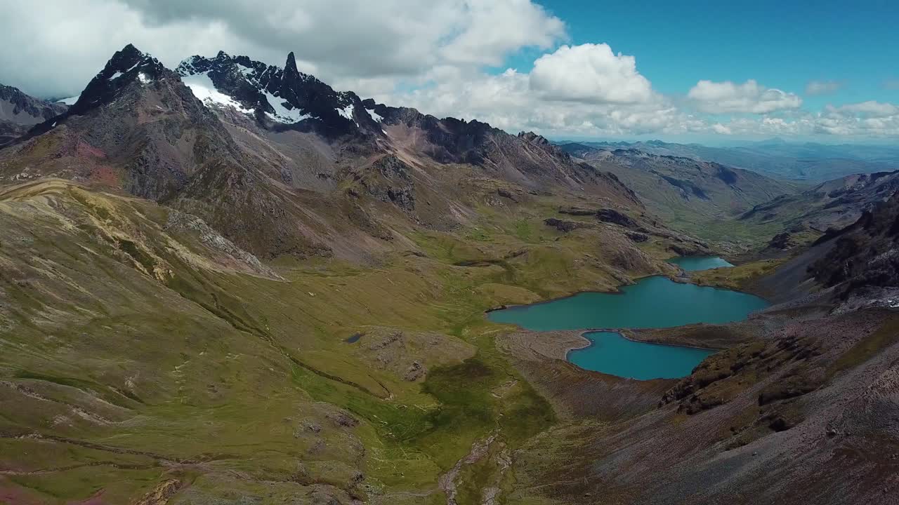 Toma aérea con dron hacia un lago en los Andes, día soleado, en la región de Cuzco, Perú