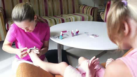 madre haciendo la pedicura de su hija