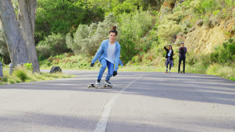 front view of cool young caucasian man doing skateboard trick on downhill at countryside road 4k