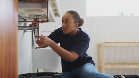 Female-Plumber-Working-To-Fix-Leaking-Sink-In-Home-Bathroom