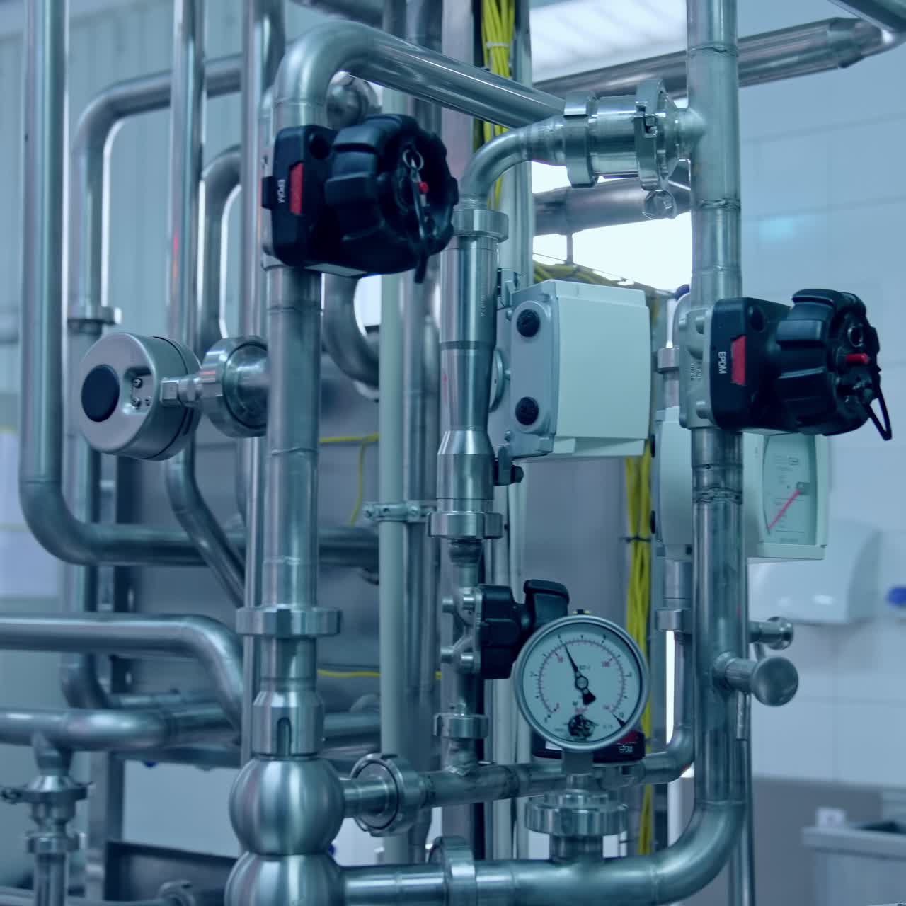 Food processing plant. New industrial equipment with metal pipes and modern appliances inside the milk factory