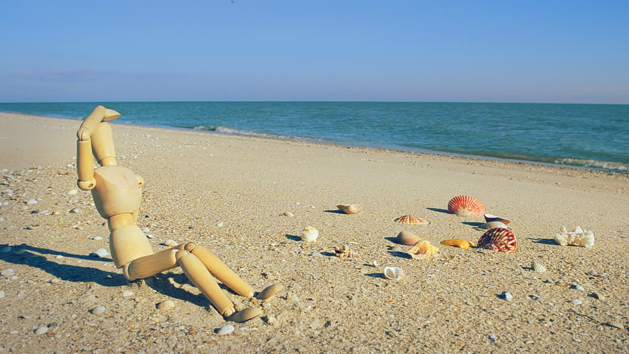 Manichino di legno sulla spiaggia. Riprese sulla spiaggia