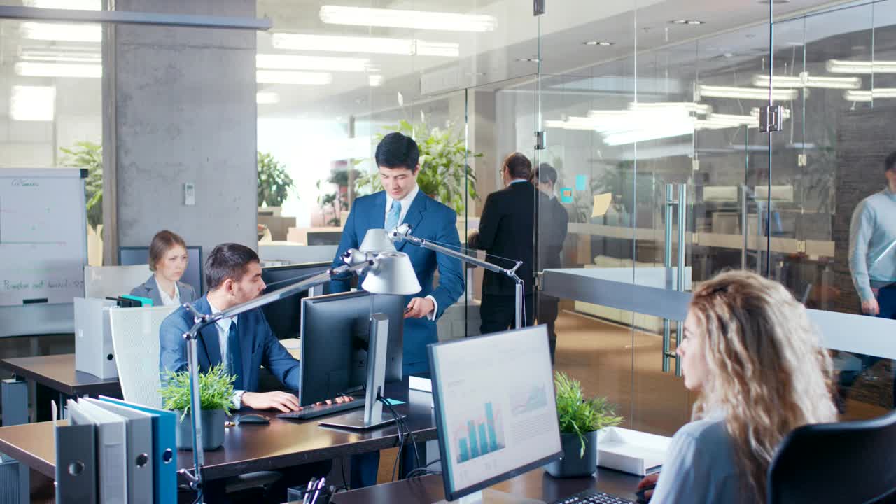 다수의 사업가들이 상호 작용하고, 문서를 공유하고, 통계와 함께 일하는 큰 사무실의 고도화 된.