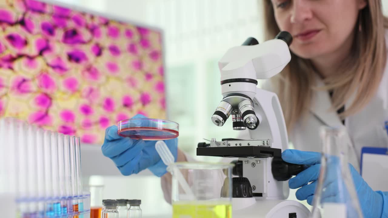 científica que usa un microscopio en un laboratorio