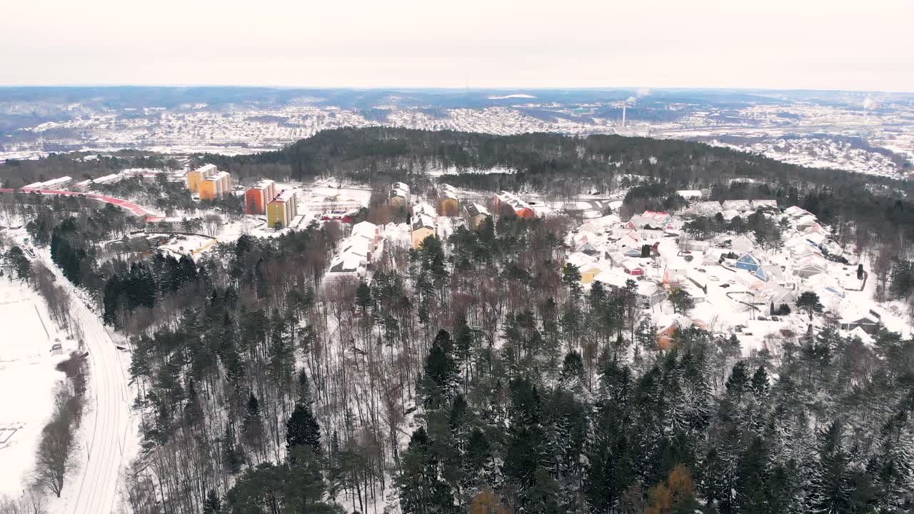 vista de pájaro del paisaje invernal que muestra un manto de nieve sobre el pueblo en los suburbios