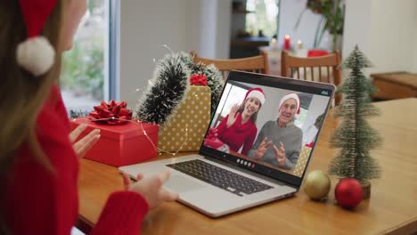 Happy-caucasian-woman-on-video-call-with-grandparents-at-christmas-time