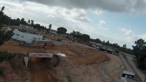 piloto de motocross saltando sobre una rampa de tierra en un circuito