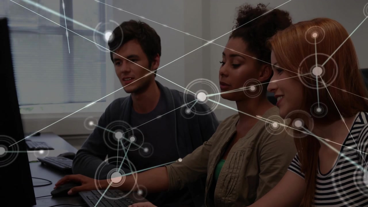 Team at computers clicking mouse and visualizing network overlay to represent data flow in tech lab