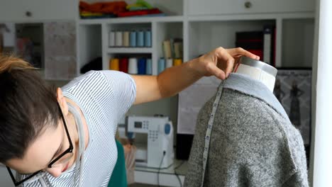 diseñadora femenina midiendo la longitud del vestido en el maniquí 4k