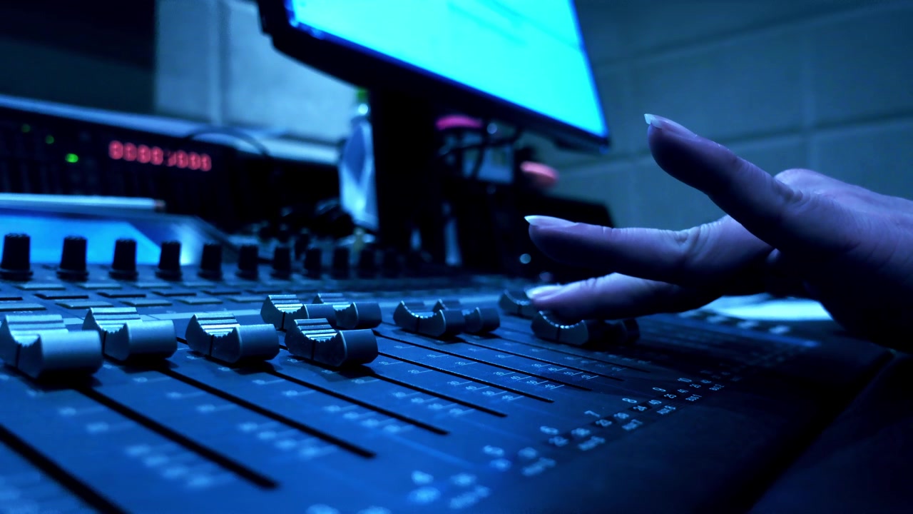 Sound engineer working in the sound studio on audio mixing machine 16 tracks with the computer for sound balance software. 4K