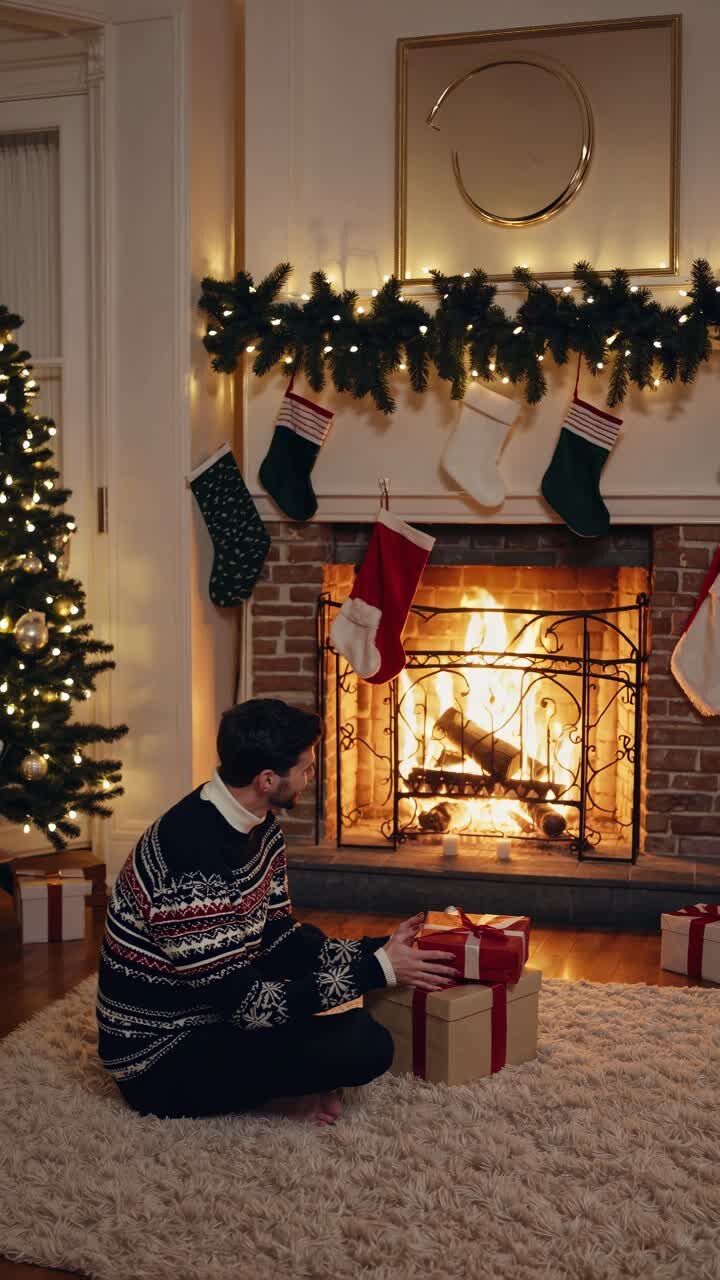 Cozy holiday scene with a man in a sweater by a fireplace, surrounded by gifts