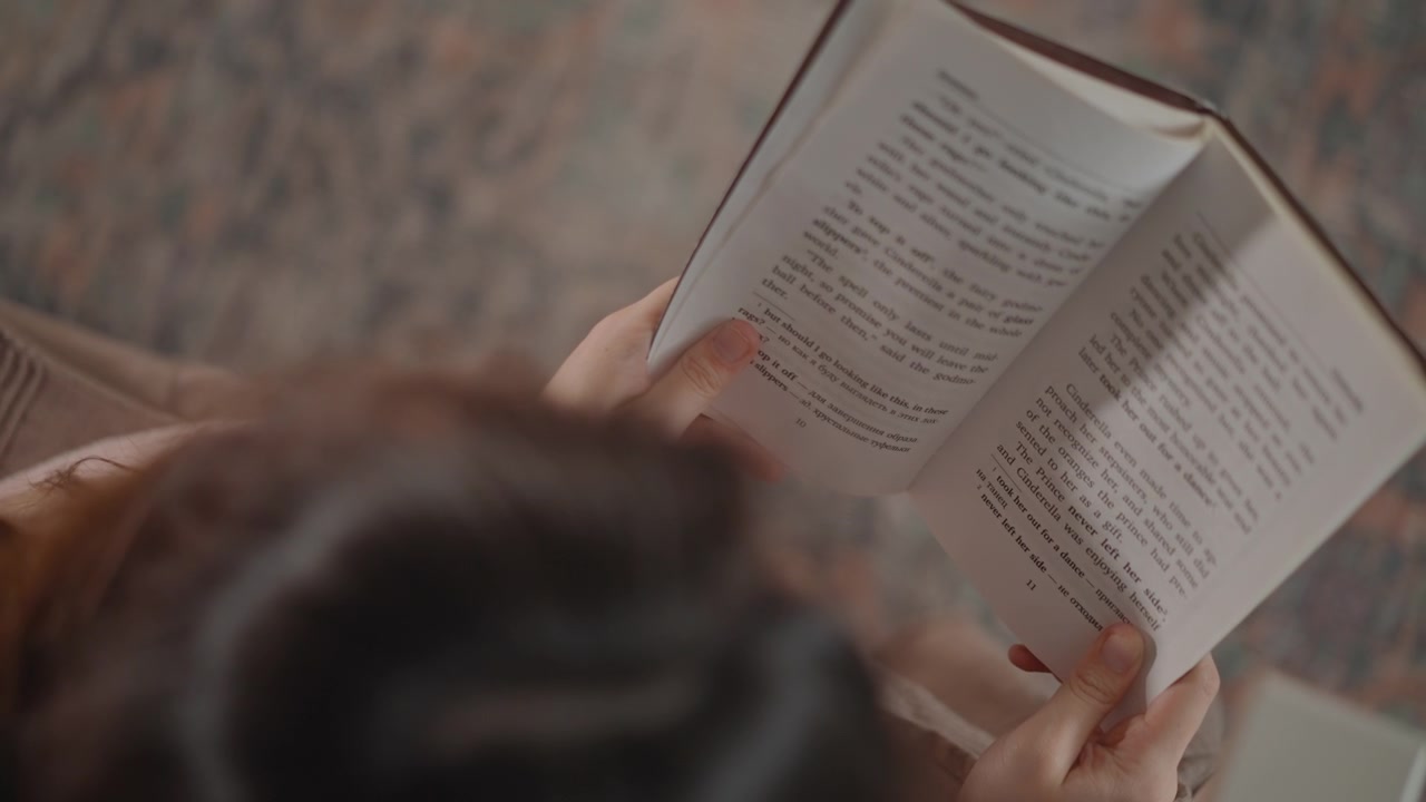 Primo piano dall'alto di una persona che tiene uno spartito stampato con entrambe le mani mentre solleva la pagina con la punta del dito, mostrando un cambio di pagina attivo e una lettura a prima vista attenta.