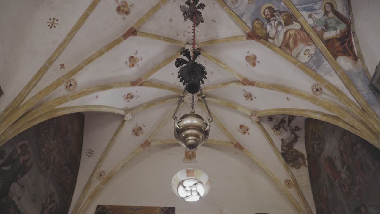 금과 복잡한 그림으로 장식 된 장식 된 구부러진 천장에 매달려있는 향신료의 도를 추적합니다.