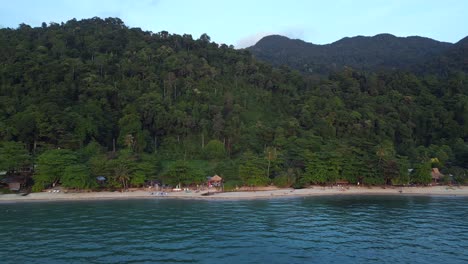 Long-sandy-beach-behind-jungle-and-mountain