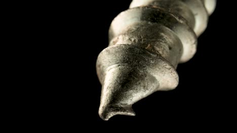 close-up of a metal screw tip on a black background