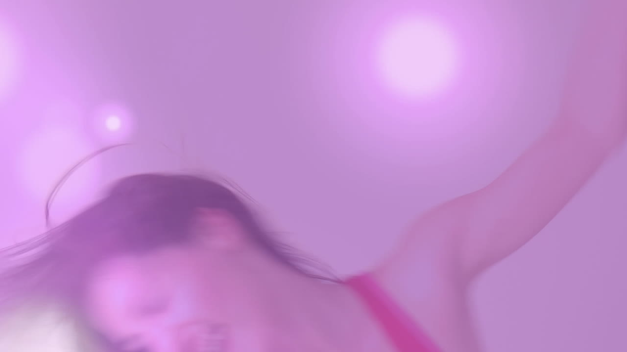 video generado digitalmente de puntos brillantes que se mueven contra la mujer bailando en el fondo