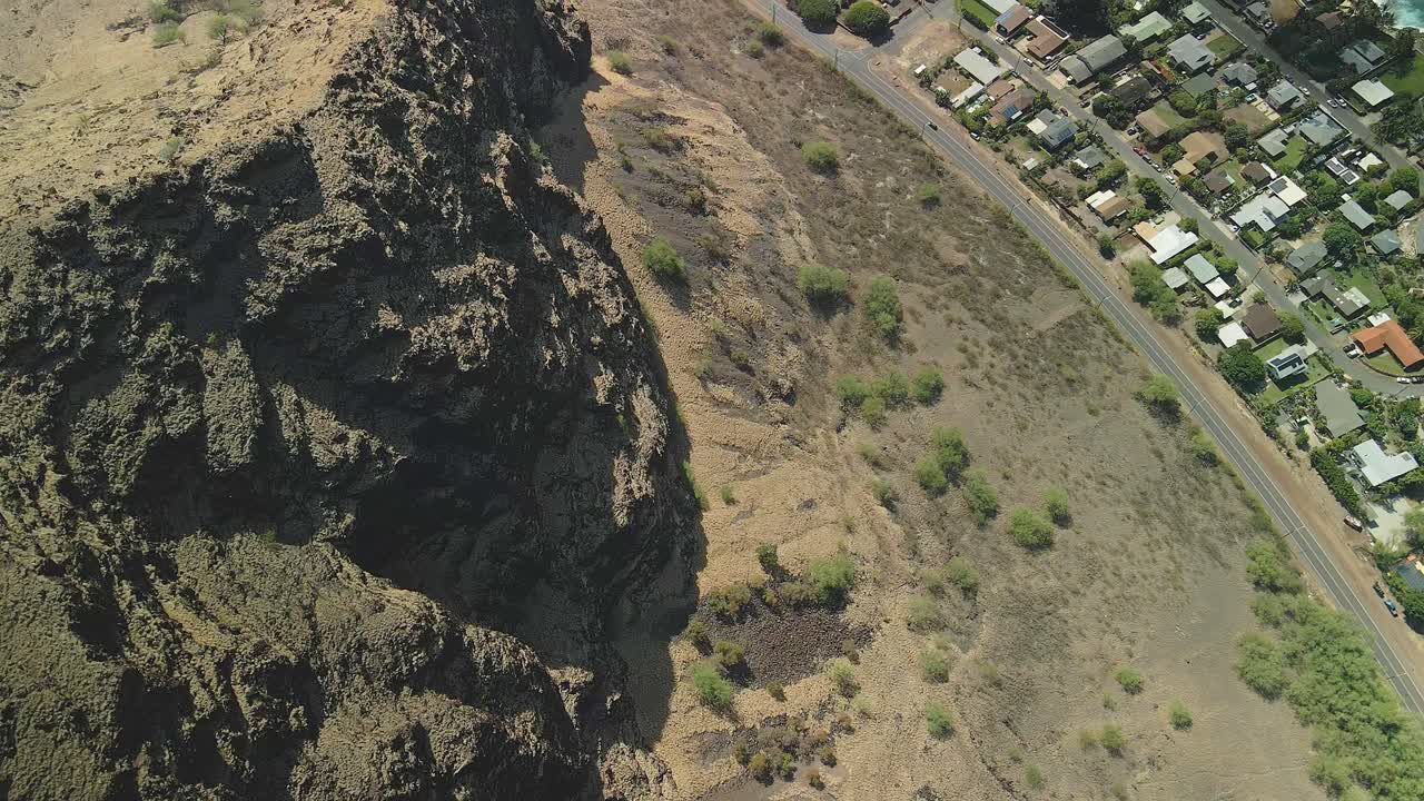 vista aérea de la empinada ladera de la montaña con vistas a la comunidad junto a la playa